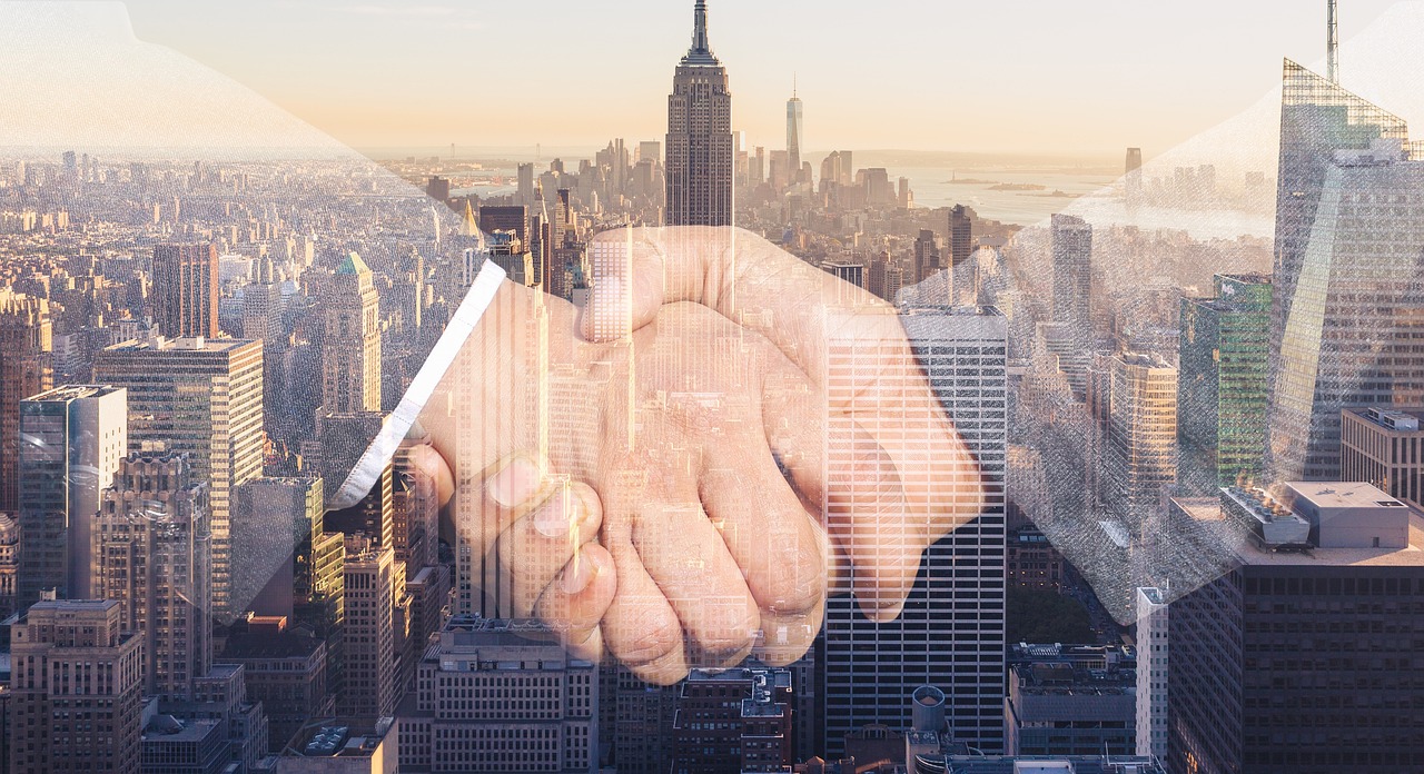 A handshake set against a city skyline, representing trusted partnership worldwide
