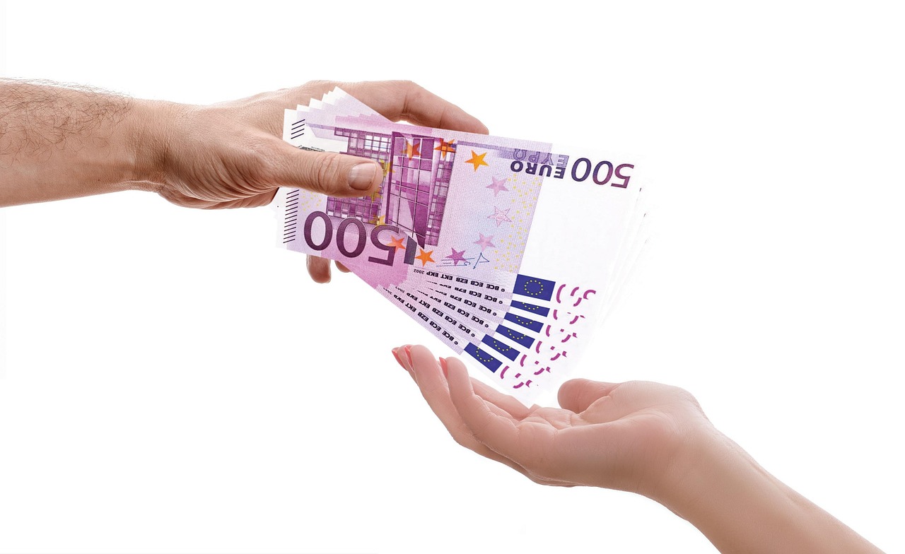 A hand passing banknotes to another, representing the shift toward secure digital payments